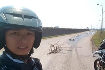 Chàng trai dựng rào chắn cảnh báo mọi người tránh vệt dầu trên đường