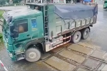 Tai xe xe ben co vuot duong sat, dam hong gac chan khi tau dang den hinh anh