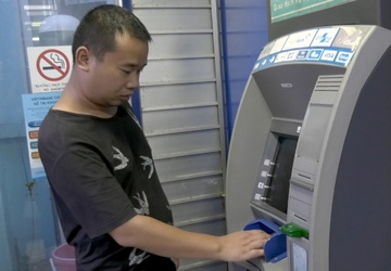 Nguoi dan ong Trung Quoc mang 102 the ATM gia di rut tien hinh anh