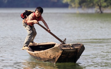Canh hoc sinh cheo thuyen qua ho nuoc sau den truong hinh anh
