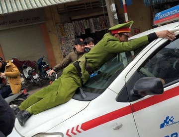 Canh sat bi tai xe taxi hat len nap capo hinh anh