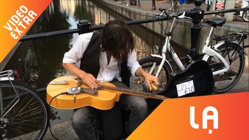 Dung binh ruou choi guitar, nguoi dan ong kiem tien tren pho hinh anh