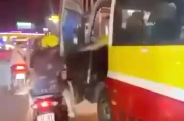 Tài xế xe buýt đẩy cửa đập vào cặp vợ chồng đi xe máy trên phố