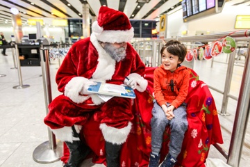 Ong gia Noel tang qua cho hanh khach nhi tren may bay hinh anh