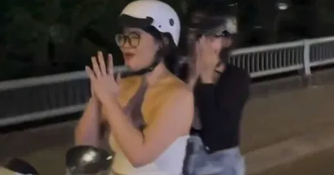 Co gai chap tay lay khi dang dieu khien xe may hinh anh