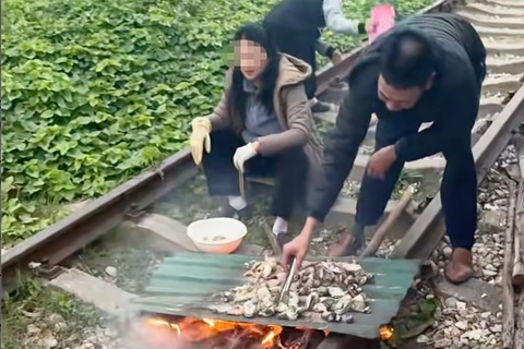 Gia dinh noi lua, nuong do an tren duong ray tau hoa hinh anh