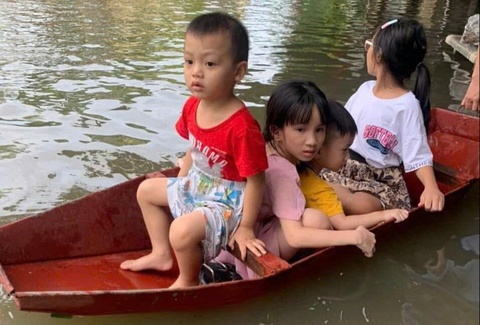 Bi hai dua con di hoc bang thuyen giua pho ngap nhu song hinh anh