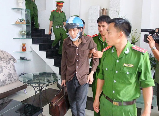 Bị can Dương (bên trái) thực nghiệm cầm túi đồ rời khỏi ngôi nhà sau khi gây án.