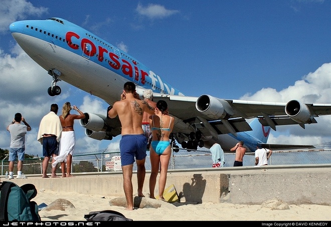 DU KHÁCH ĐỨNG GẦN ĐƯỜNG BĂNG QUAN SÁT MÁY BAY CẤT CÁNH TỪ ĐẢO SINT MAARTEN
