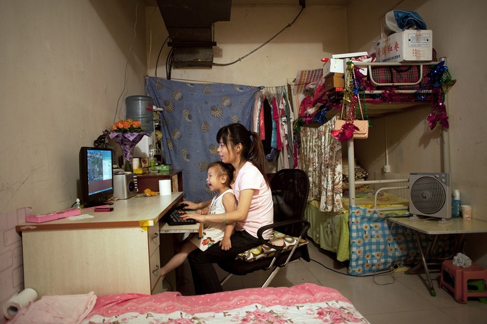 Cô Ji Lanlan, 25 tuổi, cùng con gái 3 tuổi đang chơi điện tử trên máy tính. Phòng của cô Ji là một trong những căn phòng cho thuê dưới tầng hầm có diện tích lớn. Ji đến từ tỉnh Hà Nam, hiện đang làm nhân viên văn phòng ở Bắc Kinh đã được 4 năm.