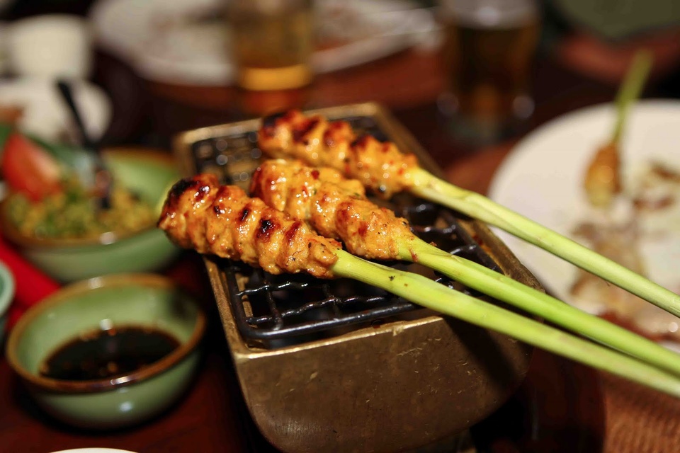 6. Sate Lilit. Sate Lilit là một món ăn đặc trưng của người dân Bali làm từ tôm, cá, hải sản rất được du khách khắp nơi trên thế giới ưa chuộng. Cá bỏ hết xương và tôm nguyên bóc vỏ, xay nhuyễn rồi ướp đều với một hỗn hợp các gia vị gồm nước cốt dừa, rau thơm, tiêu, ớt, muối, đường…sau đó dùng thân của một loại chanh cỏ đắp thịt vào rồi nướng xiên, khi chín mùi thơm xốc lên tận mũi.